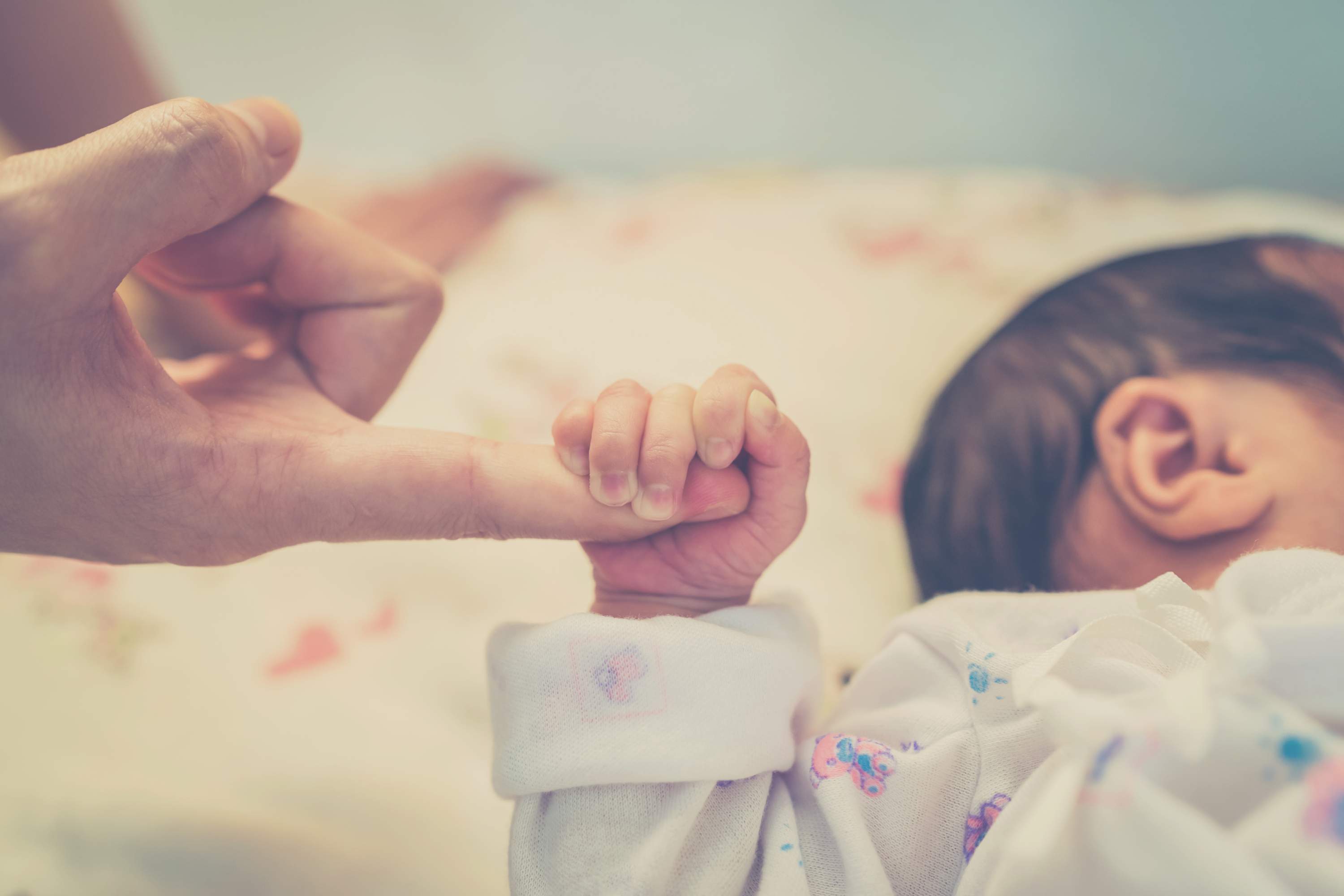 Рука новорожденного ребенка в роддоме